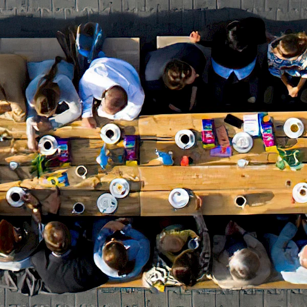 Lange Kaffeetafel mit Menschen auf Bierbänken